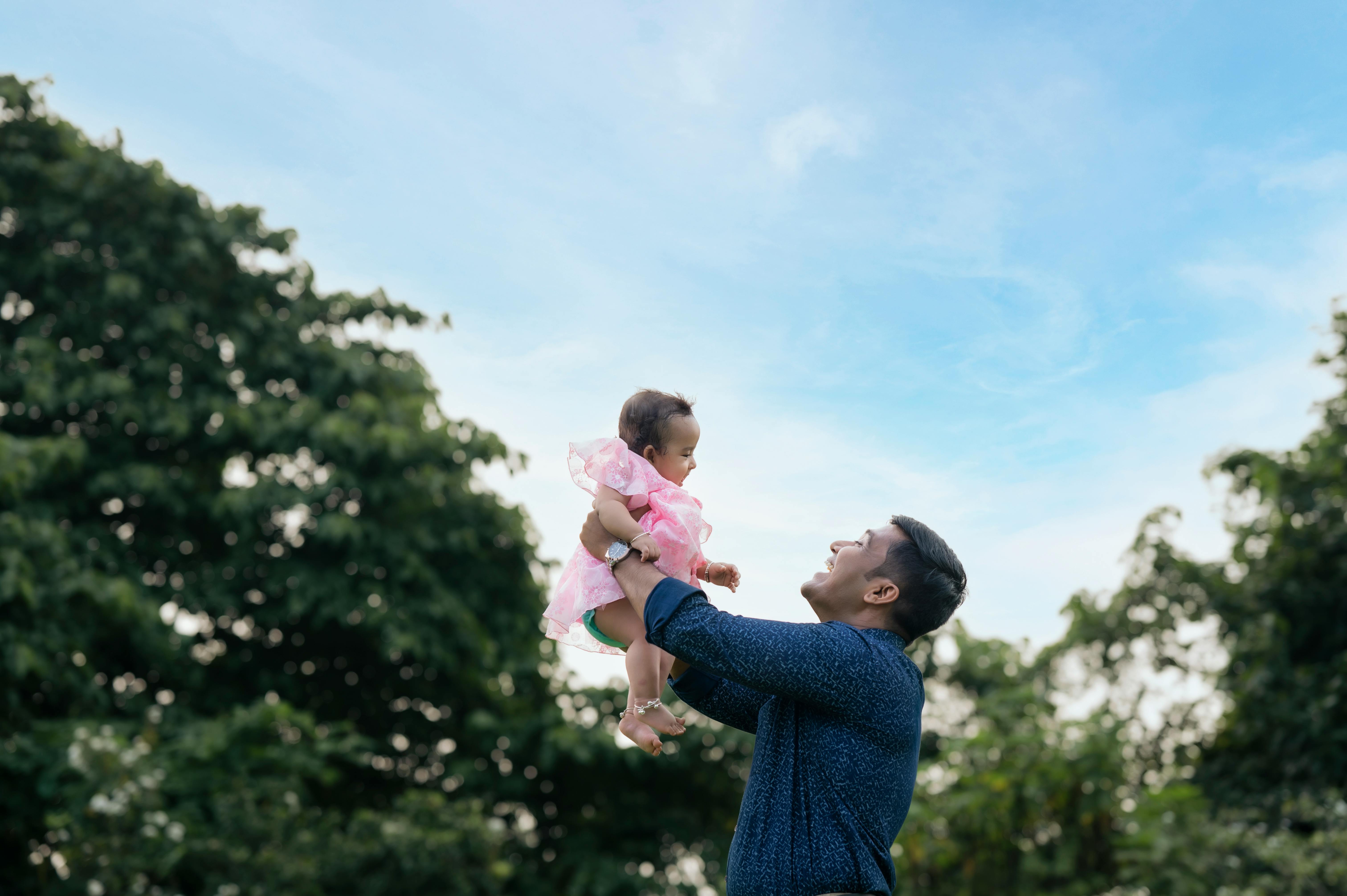 Elternzeit – Vater hebt Baby in die Luft